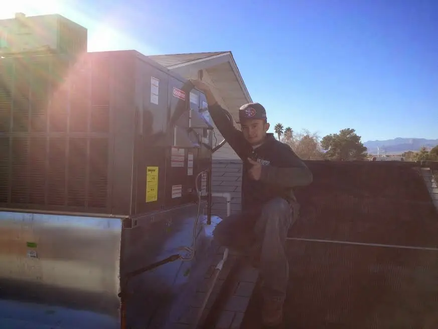 HVAC technician performing AC Tune-Up on a rooftop unit in Pleasant Prairie